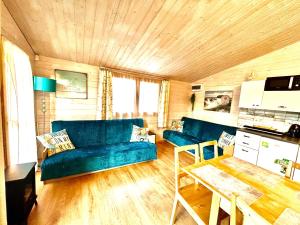 a living room with a blue couch and a table at Osada Familia in Sarbinowo