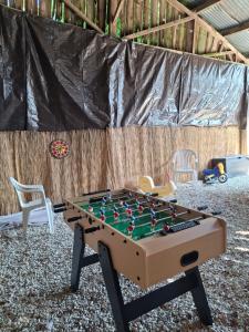 Una mesa de futbolín en una habitación con sillas. en la java, en Saint-Cyran-du-Jambot