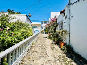 an alley with flowers and a white fence at Amanecer Santorini in Doradal