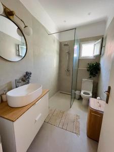 a bathroom with a sink and a toilet and a mirror at Casa Nostra, Stroggili Corfu in Agios Ioannis Peristeron