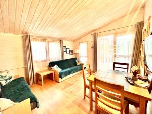 a living room with a green couch and a table at Osada Familia in Sarbinowo +59 photos