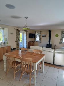 a kitchen and living room with a wooden table and chairs at 2 Bed House - Sleeps 4 - Fishing - Parking - Patio in Abergavenny +3 photos