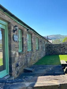 a stone building with a bench outside of it at 2 Bed House - Sleeps 4 - Fishing - Parking - Patio in Abergavenny