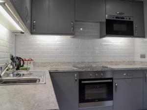 a kitchen with a sink and a stove top oven at The Milking Parlour - Uk30866 in St Bees