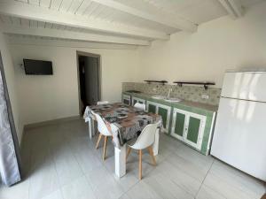 a dining room with a table and white chairs at Casa vacanze Villa Marta in Porto San Giorgio +3 photos