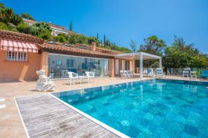 a house with a swimming pool and a patio at Studio Palmeraie in Saint-Raphaël