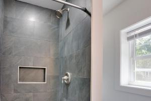 a bathroom with a shower with a stone wall at Shared Boat Ramp at Kentucky Lake Retreat in New Johnsonville +16 photos