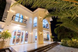 a large white house with a palm tree at Yubi Villa Private Swimming Pool 100m2 - Super Vip in Vung Tau