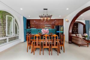 a dining room with a table and a kitchen at Yubi Villa Private Swimming Pool 100m2 - Super Vip in Vung Tau