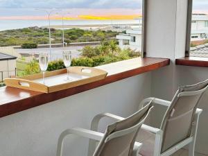 a table and two chairs and a window with wine glasses at Ocean View Sunset Resort in Perth