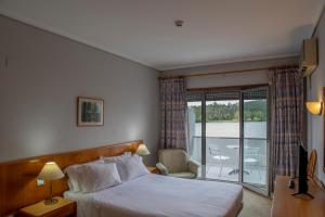 a hotel room with a bed and a balcony at WOT Pateira in Fermentelos +35 photos