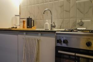 un comptoir de cuisine avec un évier et une cuisinière dans l'établissement Moka - Holiday Home by the Sea, à Barra de Portezuelo