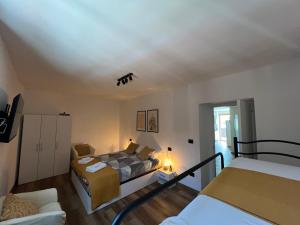 a small bedroom with a bed and a couch at Le Calle Holiday Apartments in Nago-Torbole