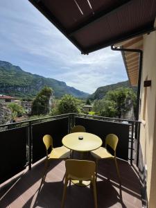 a balcony with a table and chairs and mountains at Le Calle Holiday Apartments in Nago-Torbole