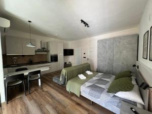 a small bedroom with a bed and a kitchen at Le Calle Holiday Apartments in Nago-Torbole