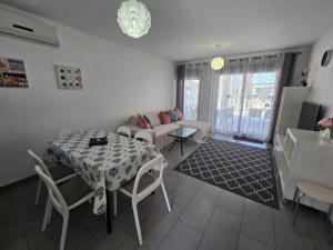 een woonkamer met een tafel en een bank bij Sunny Ground floor bungalow opposite the swimming pool in Orihuela