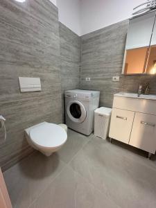 a bathroom with a toilet and a washing machine at Suba's Apartment Free Parking Self Check-in in Timişoara