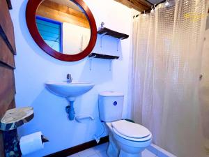 ein Badezimmer mit Toilette, Waschbecken und Spiegel in der Unterkunft Cabañas rurales Aldea de Cabal - Naturaleza y Sabor cerca a Termales Reservamos tu entrada a termales Santa Rosa in Santa Rosa de Cabal