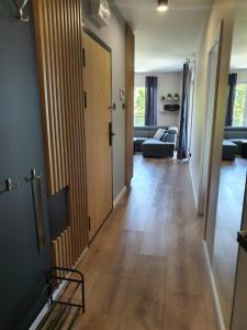 a hallway with a door and a living room at Mazury Home Apartament in Giżycko