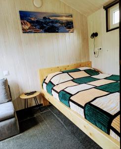 een kleine slaapkamer met een bed en een stoel bij Gästehaus "Säntis" in Carnikava