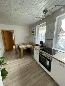 a kitchen with a table and a stove top oven at Altstadtferienwohnung Einbeck in Einbeck +13 photos