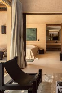 um quarto com uma cama e uma cadeira em NABOA Hotel Tulum em Tulum