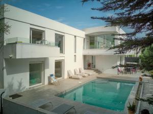 a large white house with a swimming pool at FRGK "Villa Hameau des collines" in Le Cannet