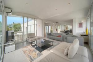 a living room with a couch and a tv at FRGK "Villa Hameau des collines" in Le Cannet