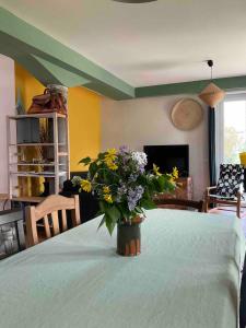 a vase of flowers sitting on a bed in a room at Casa Rossa in Montecassiano