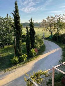 a winding road with trees and flowers in a field at Casa Rossa in Montecassiano