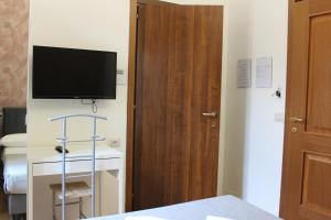 a room with a tv on the wall and a door at Rooms Piramide 1 in Rome +8 photos