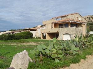 una casa con un giardino con una roccia davanti di Résidence Fioravanti Villas Valinco a Tizzano