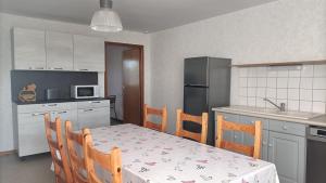 a kitchen with a table and chairs and a kitchen with a refrigerator at Home 18 in Tavaux
