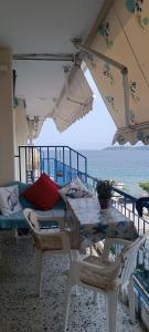 a table and chairs under an umbrella on the beach at Sea view in Nea Peramos