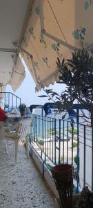 a balcony with a table and chairs and an umbrella at Sea view in Nea Peramos