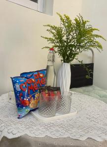 Una mesa con una botella de snacks y un jarrón con una planta. en Bé Homestay, en Hai Phong 6 fotos más