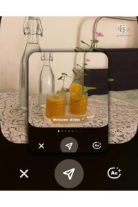 a picture of a bottle and two glasses of orange juice at Bé Homestay in Hai Phong