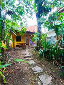 a path in front of a house with a bench at Casa Canto Verde in Itacaré