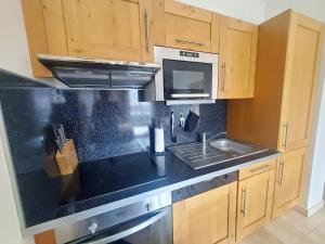 - une cuisine avec un plan de travail noir et un évier dans l'établissement Le Sarment Cottage - F3 Luxury with Pool, à La Croix-Valmer 34 autres photos