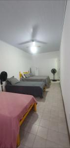 a room with two beds and two tables in it at Suites Praia Forte Dunas in Cabo Frio