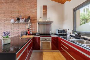 a kitchen with red cabinets and a brick wall at CIM Apartments in Olivella