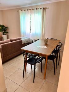 a dining room table and chairs in a living room at Apê 202 - Central, Garagem e Ar Cond - 2Q e 2B in Governador Valadares