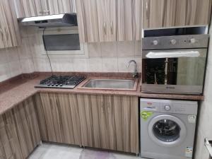 a kitchen with a sink and a stove and a dishwasher at Zamalek cosy house in Cairo +12 photos