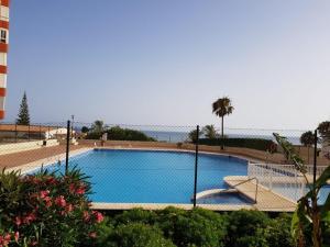 a swimming pool with the ocean in the background at La Corbeta in Torrox Costa