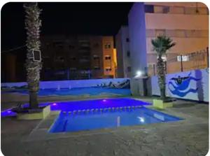 a swimming pool with blue lights in a building at Bouchra in Martil