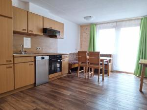 a kitchen with wooden cabinets and a table with chairs at Wolke7 Family First in Sankt Anton am Arlberg
