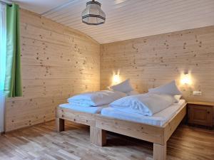 a bed in a room with a wooden wall at Wolke7 Family First in Sankt Anton am Arlberg