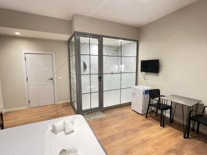um quarto amplo com uma mesa e um frigorífico em Serene Stay em Vlorë