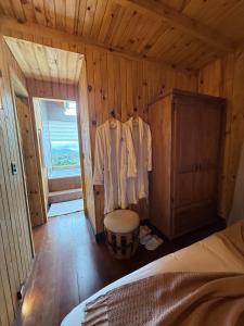 a bedroom with a bed and a wooden wall at Pousada Vale do Charao in Bocaina do Sul