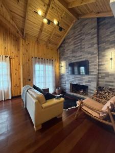 a living room with a couch and a fireplace at Pousada Vale do Charao in Bocaina do Sul